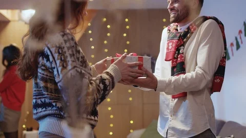 Young bearded happy man passing a Christmas gift box for red-haired woman Stock Footage 121471005
