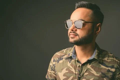 Young bearded Indian man against gray background Studio shot of young bear... Stock Photos
