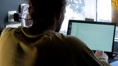 Young bearded male programmer coding at laptop in dark room Stock Footage 105337609