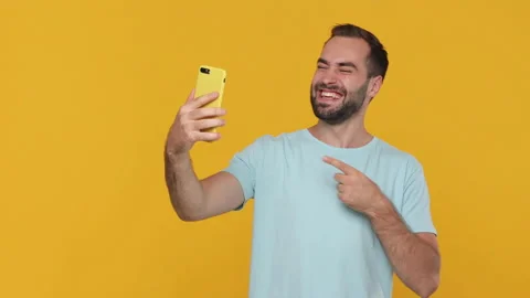 Young bearded man 20s in basic casual blue t-shirt using mobile cell phone doing 스톡 동영상 148290313
