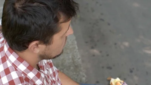 Young bearded man biting hot dog with red onion. Clouse up Stock Footage 79496076