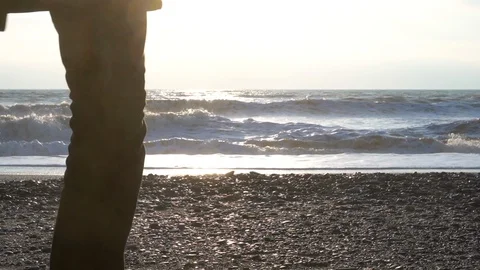 Young bearded man in black clothes is walking along the beach at the sunny day. Stock Footage 127255543