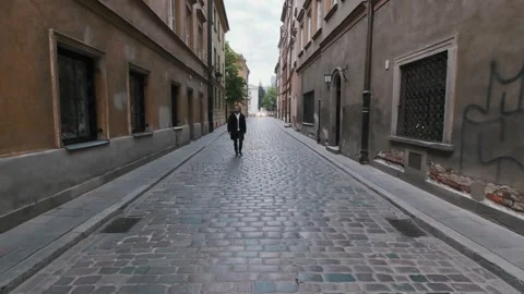 Young bearded man in a black coat walking streets of old city. Warsaw, Poland Stock Footage 132301822