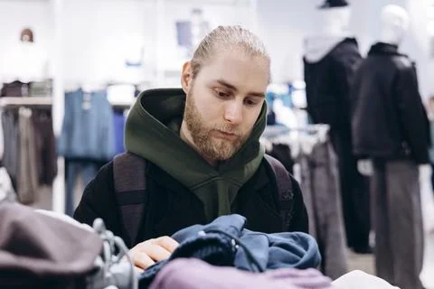 Young bearded man browsing clothes in a modern fashion store. Foto stock