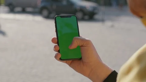 Young bearded man browsing mobile app on vertical smartphone chrome key mock-up Stock Footage 117428046