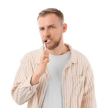 Young bearded man brushing teeth on white background Stock Photos