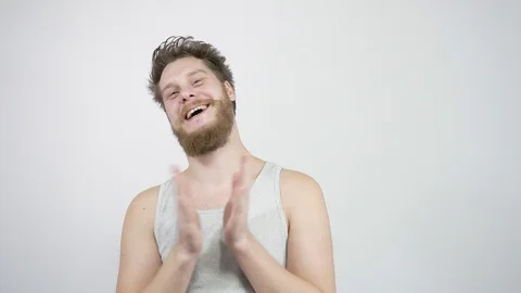 A young bearded man claps his hands and smiles approving of what he saw Stock Footage 121683014