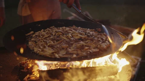 Young bearded man cooking on open fire bbq at evening Vídeo Stock 164072830