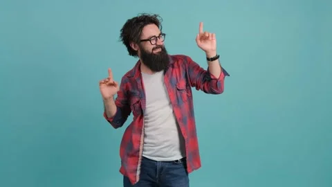 Young bearded man dancing and posing over turquoise background. Stock Footage 141187387