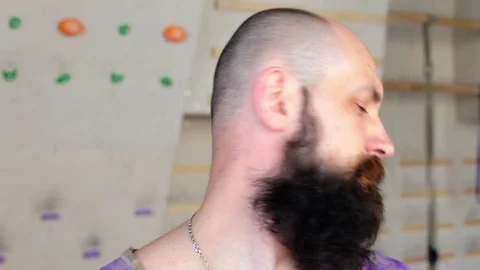 Young bearded man doing workout. Man makes circular turns head stretching neck Stock Footage 77801800