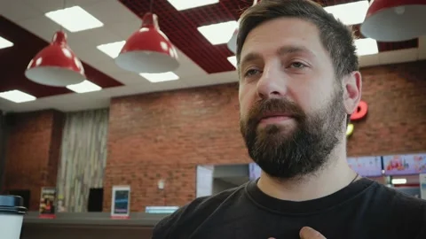 Young, bearded man drinking tea and having fun at the bar Stock Footage 98179569