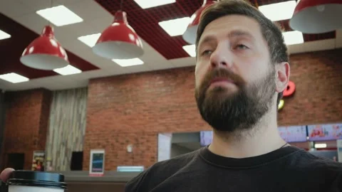Young, bearded man drinking tea and having fun at the bar Vidéo 98180747
