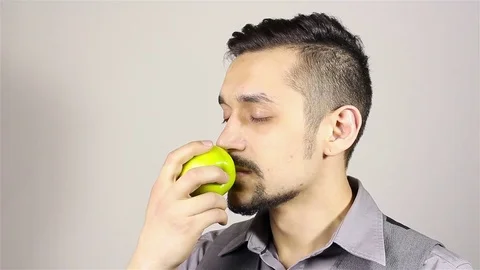 Young bearded man eating an apple Stockbeeldmateriaal 75391897