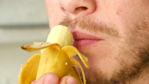 Young bearded man eating a small banana Stock Footage 337548354