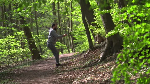 Young Bearded Man Exercising with Resistance Bands in Lush Forest Stock Footage 130782289