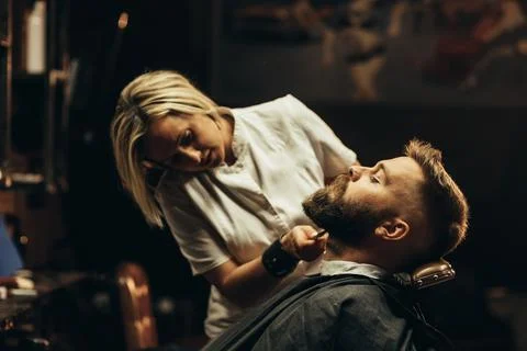 Young bearded man getting beard haircut by hairdresser Stock Photos