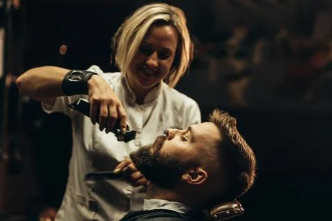 Young bearded man getting beard haircut by hairdresser Stock Photos