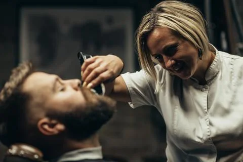 Young bearded man getting beard haircut by hairdresser Stock Photos