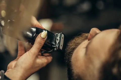 Young bearded man getting beard haircut by hairdresser Stock Photos