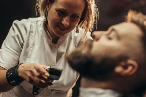 Young bearded man getting beard haircut by hairdresser Stock Photos