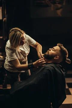 Young bearded man getting beard haircut by hairdresser Stock-Fotos