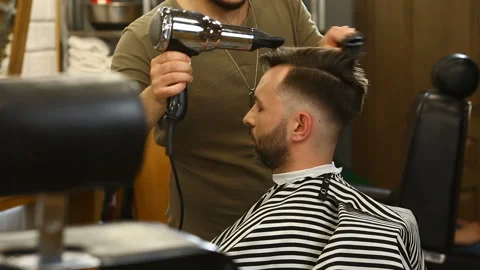 Young bearded man getting his hair blow dried Stock Footage 91213316