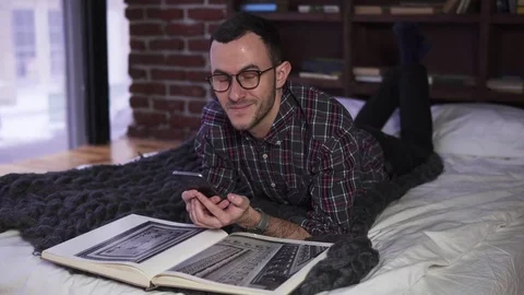 Young bearded man with glasses looking at the smartphone screen Stock Footage 84848680