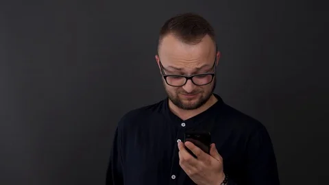 A young, bearded man with glasses. Studio shot of male disparagingly reacts  Stock Footage 90230182