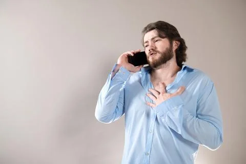 Young bearded man having call and talking on smartphone with pleasure isolate Stock Photos