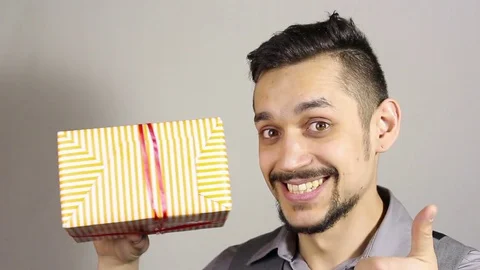 Young bearded man looking at a gift. Stock-Footage 73719696