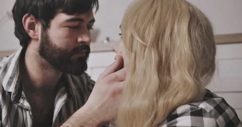 Young bearded man looking with love at pretty young white hearted woman Video stock 148895575