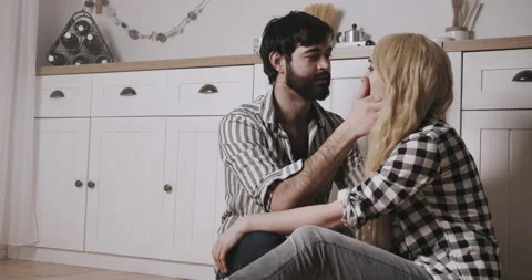 Young bearded man looking with love at pretty young white hearted woman Stock Footage 148895595