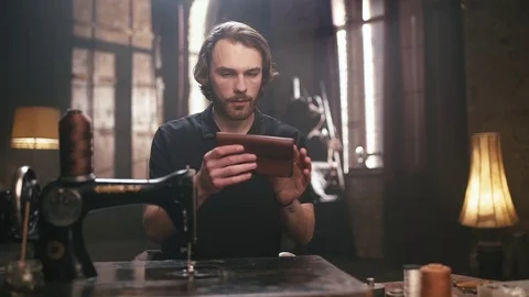 The young, bearded man, makes leather goods Stock Footage 71798668