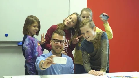 A young bearded man makes a selfie with a group of his schoolkids Stock Footage 70607889