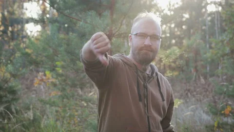 Young, bearded man negative sign, shows thumb down Stock Footage 100668693