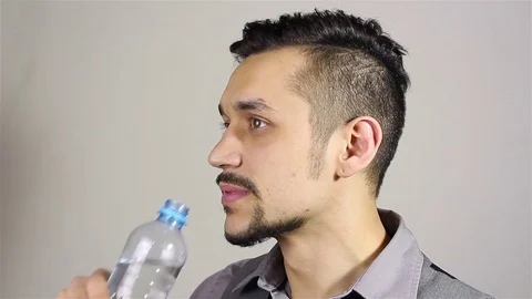 Young bearded man opens a bottle and drink water Stock-Footage 75352065