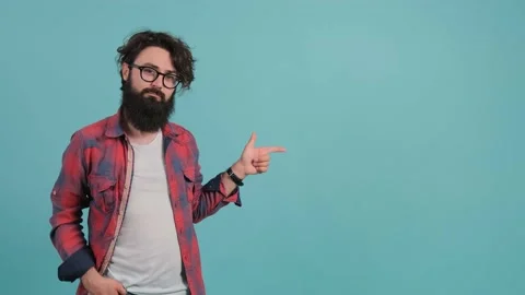 A young bearded man is pointing to the left and nods. Stock Footage 139692002