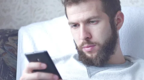 A young bearded man poses a face using his mobile phone Stock Footage 68918187