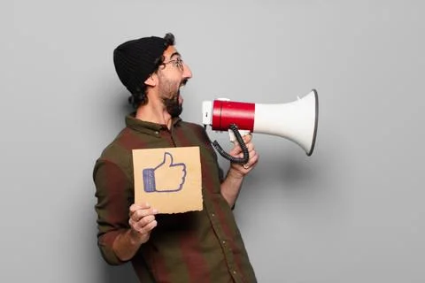 Young bearded man protesting with a megaphone Stock Photos
