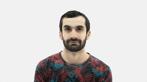 Young a bearded man raises one eyebrow and then laughs Stock Footage 107433260