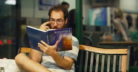 Young bearded man reading and sitting on bench and gets up when a sweaty man sit Stock Footage 199456022