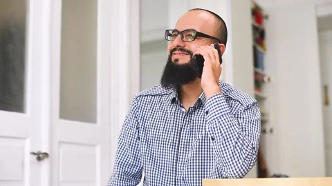 Young bearded man sitting and using phone at living room. Stock Footage 140270308