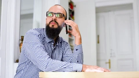 Young bearded man sitting and using phone at living room. Stock Footage 140284756