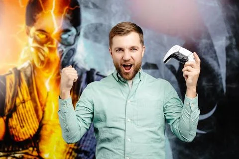 Young bearded man standing at the wall in the room and playing, holding wir.. Stock Photos
