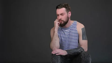 Young bearded man taking thought isolated on dark gray background Stock Footage 251464407