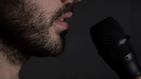 Young bearded Man talks to microphone. Man microphone speech, close up side view Stock Footage 126288798