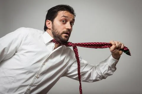Young bearded man with tie pulling himself Stock Photos
