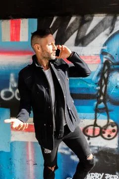 A young bearded man using the cell phone in the city Stock Photos
