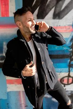 A young bearded man using the cell phone in the city Stock Photos