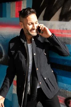 A young bearded man using the cell phone in the city Stock Photos